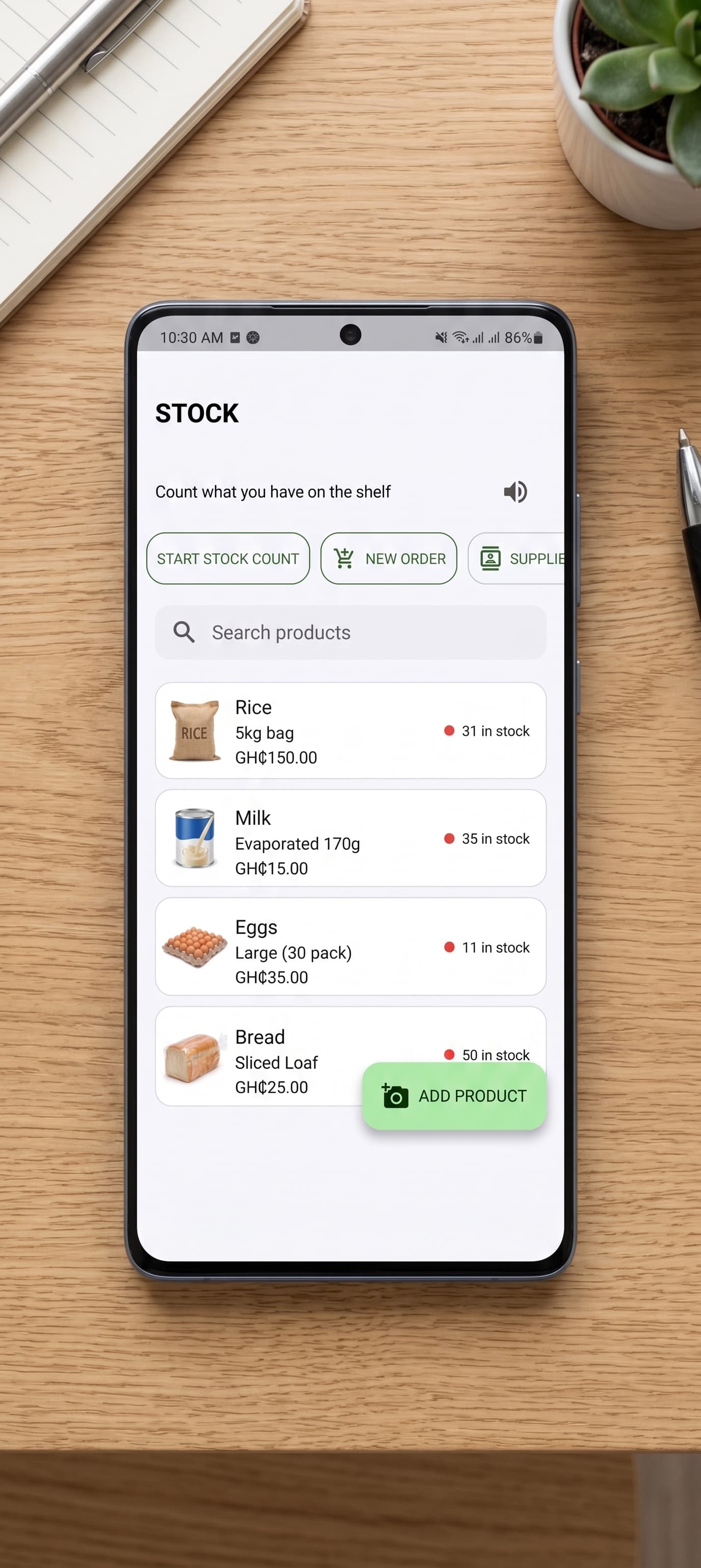 The STOCK screen showing product quantities, photographed on a desk